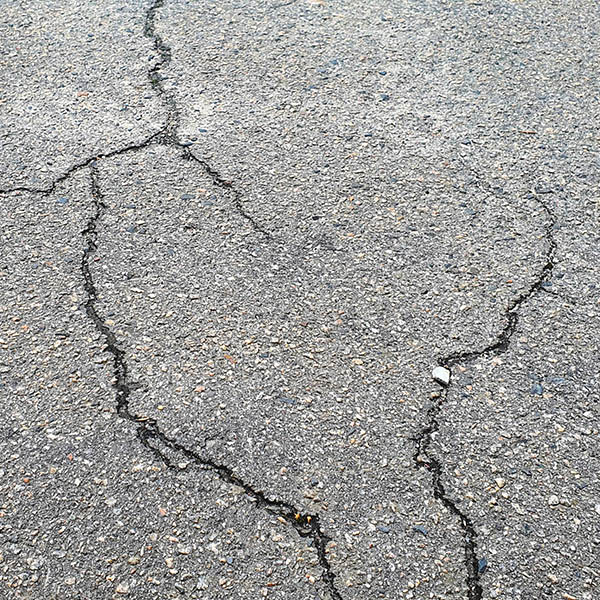 Cracks in the asphalt. An old driveway with cracked asphalt. 