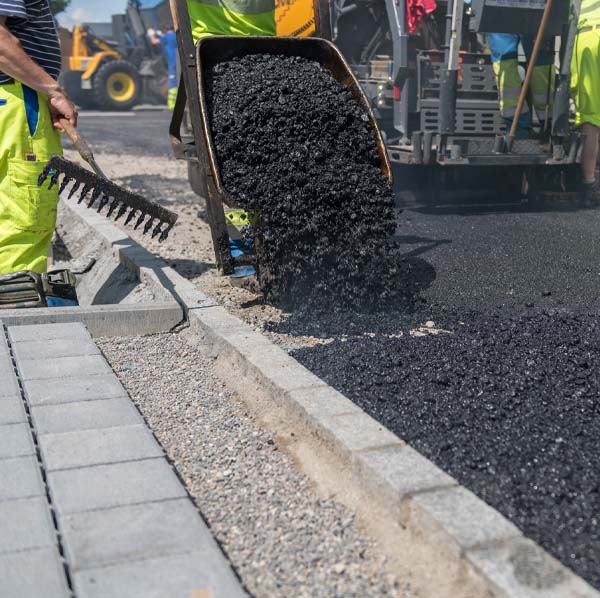 industrial pavement truck laying fresh asphalt on construction site, asphalting
