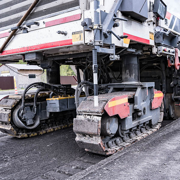 self-propelled tracked road milling cutter for removing old asphalt pavement during road repairs. Large Road cold milling machine removes the old asphalt and loading into a dump truck.