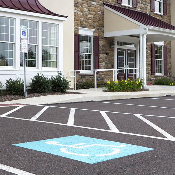 Handicap parking at a recently finished medial office. Focus is on the handicap symbol on the pavement.